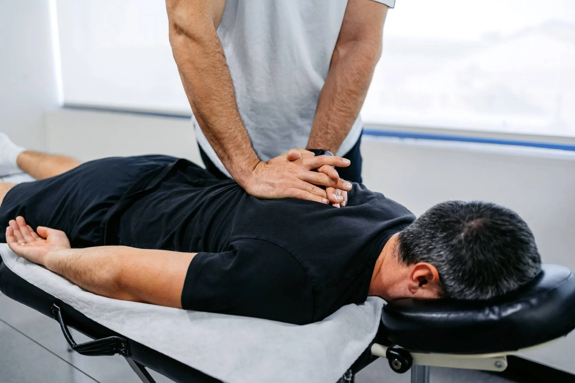 Chiropractic Massage Explained Chiropractic Massage Explained - ChiropractorAdjustingHisMaleClient27sUpperBackInHisOffice