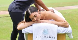 Swedish massage therapist performing long flowing strokes on a client's back at home